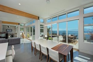 A kitchen area with floor to ceiling hurricane replacement windows.